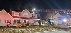 Members from E-15 & 7 operating hose lines to extinguish fire on outside of the house and inside the attic area